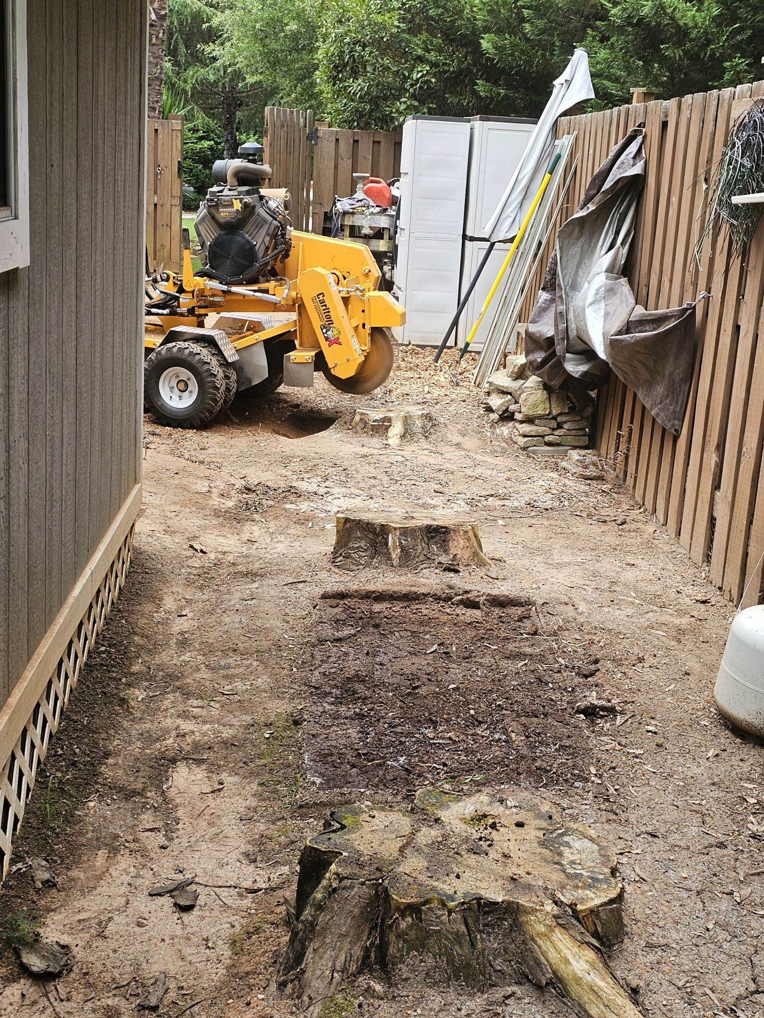 A man in yellow jacket standing next to a pile of dirt.